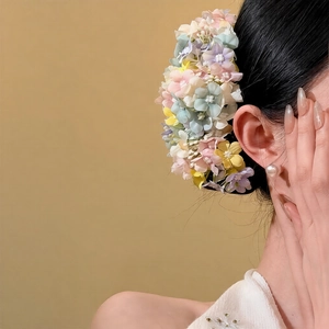 Detail of fabric flower hair pin featuring pastel clusters for elegant styling