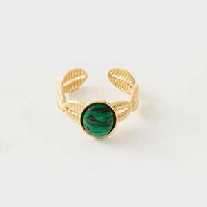 Detailed view of bohemian gold ring with green stone inlay and feather engraving
