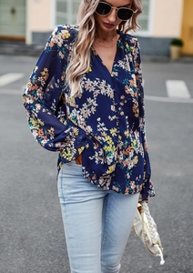 Dettaglio della camicetta blu scuro a fiori da donna con scollo a V e polsini a volant