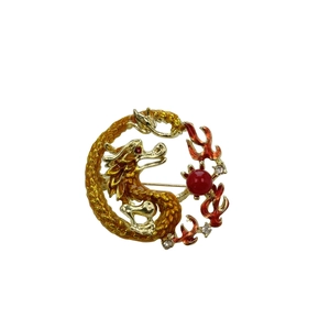 Macro detail of Chinese zodiac dragon brooch with red enamel and sparkling rhinestones