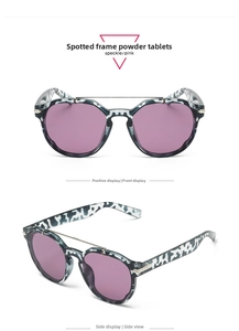 Detail of tortoiseshell patterned frames with pink purple lenses and double bridge design