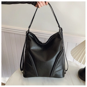 Close-up of black PU leather hobo bag with dual zipper detail on a marble surface