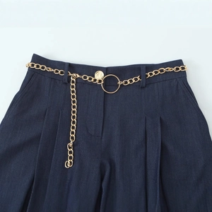 Pantalon décontracté bleu foncé avec ceinture chaîne dorée et boucle métallique à la taille