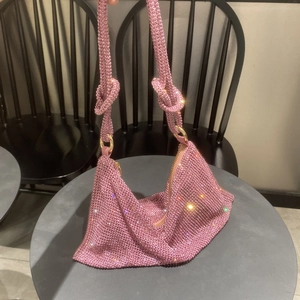 Detailed shot of pink rhinestone hobo bag with knotted strap and gold hardware accents