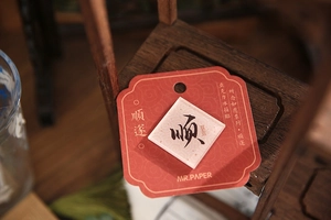 Macro view of Chinese calligraphy Shuan on a white acrylic magnet with decorative card