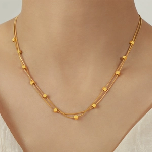 Double-layered golden snake chain necklace with small square beads for a stylish look