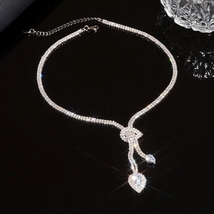 Macro shot of silver-colored water drop pendant necklace with rhinestones on black background