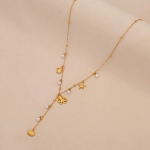Detail of gold necklace featuring sea turtle, starfish, and octopus charms with white pearls