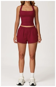 Détail du short de sport taille haute bordeaux et du haut dos nu sur modèle