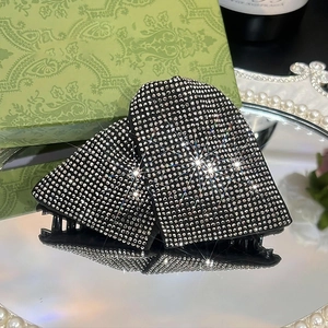Elegant triangle hair claw with sparkling rhinestones on a black acrylic base