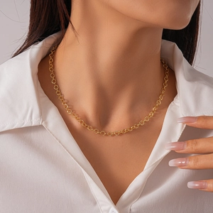 Close-up of golden geometric circle necklace on model neck with white shirt background