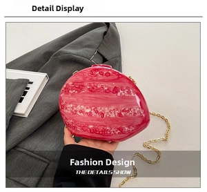 Detail of pink marble acrylic clutch bag with artistic texture and gold chain strap