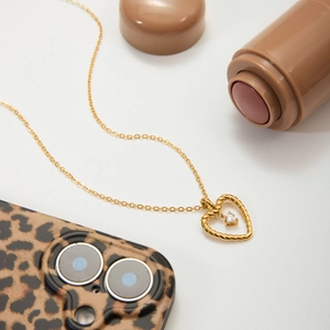 Detailed view of heart-shaped twisted rope necklace with sparkling gemstone on a white background