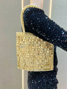 Detailed close-up of golden sequin weave and metallic texture on a square tote bag