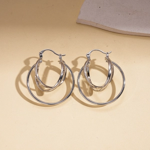 Macro shot of silver multi-layered geometric circular drop earrings on a stone surface