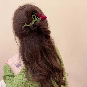 Elegant flocked tulip hair clip worn by a model with long wavy hair on a warm background