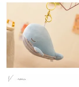 Close-up of blue plush whale keychain with soft texture and golden metal clasp