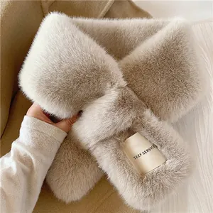 Detail of oat beige plush faux fur scarf showing soft texture and brand woven label