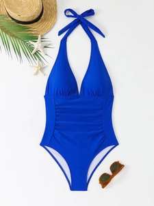 Detail of royal blue one-piece swimsuit featuring elegant halter neck and slimming ruched waist