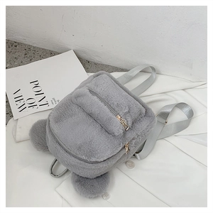 Detail view of grey plush backpack with cute bear ears and front zipper pocket on white fabric