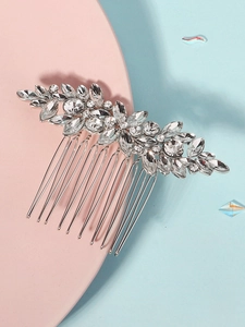 Detailed view of silver bridal hair comb with crystal rhinestones on pink and blue surface