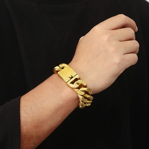 Close-up of gold Cuban link bracelet for men with detailed engraving on thick metal clasp