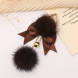 Portachiavi con pompon in ecopelliccia marrone, fiocco in nastro e campanellino d'oro