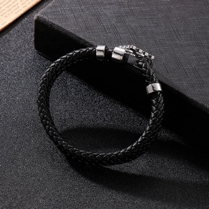 Detailed close-up of woven black leather strap with polished steel cross clasp and metal rings