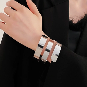 Detailed view of wide triple-layer silver spiral cuff bracelet on a model wearing black