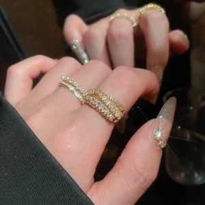 Close-up of sparkling zircon rings set in gold with micro-inlaid stones and pearls