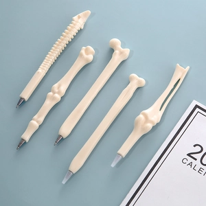 Five bone-shaped novelty ballpoint pens in various skeletal designs on light blue background