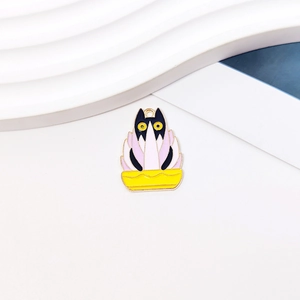 Macro shot of an enamel DIY cat pendant in a pink lotus flower pot on white background