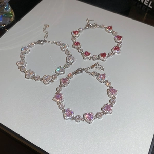 Detailed view of heart-shaped zircon bracelets in silver, pink, and red crystal options