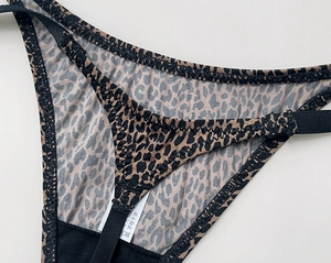 Gros plan d'un tanga léopard avec coutures précises et fines bretelles élastiques