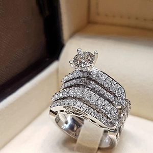 Macro shot of silver wedding ring set with four-prong center stone and pavé cubic zirconia