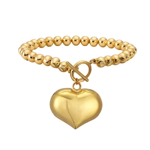 Golden beaded chain necklace with large heart pendant and OT toggle clasp on white background