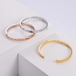 Three geometric chain links bracelets in silver, gold and rose gold on white podiums