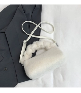 Close-up of white faux fur handbag with woven plush handle and adjustable strap