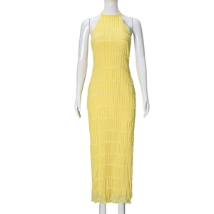 Detail view of yellow halter dress featuring unique pleated fabric and backless design