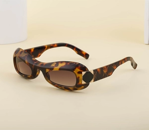 Detail of leopard print oval sunglasses with brown gradient lenses and gold metal hinge