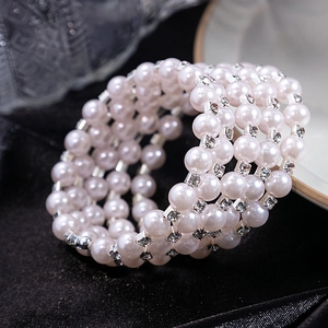 Multi-layer pink pearl wrap bracelet with rhinestone accents on black silk background
