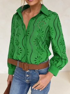 Close-up of green embroidered hollow-out button-up shirt with puff sleeves detail