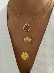 Three-layer gold necklace with shell, butterfly charms, and sparkling white zircon detail