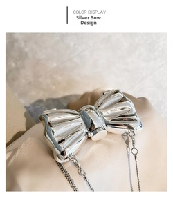 Close-up of a silver mirror acrylic bow mini bag with metallic chain detail