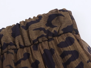 Dettaglio dei pantaloni leopardati con elastico in vita e trama del tessuto plissettato
