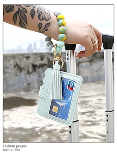 Silicone bead wristlet keychain with leather card holder and tassel on travel suitcase