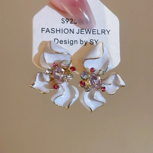 Detailed close-up of S925 silver flower earrings with white enamel and colorful crystals