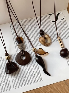 Detailed close-up of Bohemian wood and resin geometric pendants on vintage necklaces