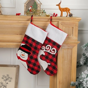 Classic red black plaid Christmas stockings with snowman and reindeer hanging on fireplace