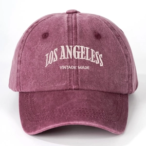 Close-up of Los Angeles white embroidery on a vintage washed purple cotton baseball cap
